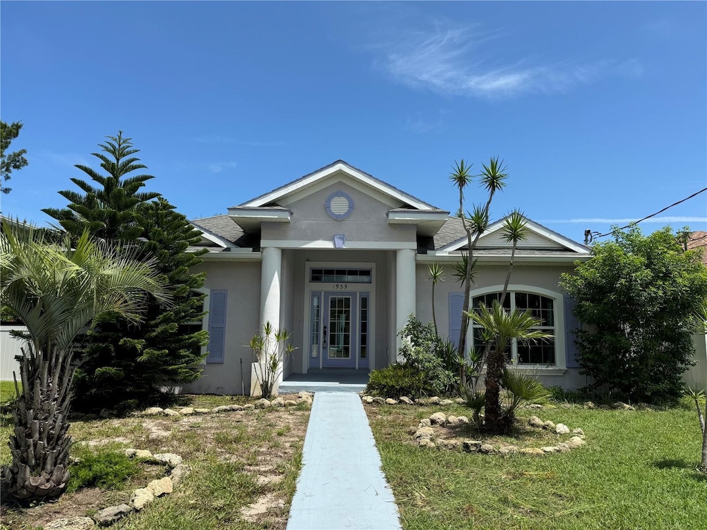 view of front of home featuring stucco siding and roof with shingles