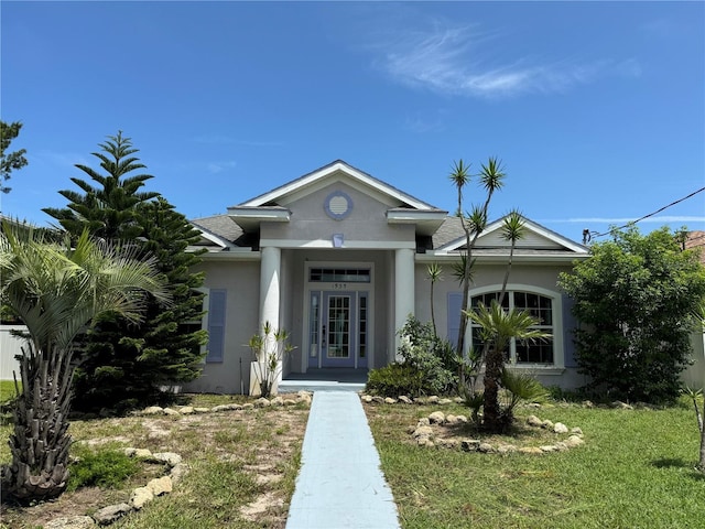 view of front of home featuring stucco siding and roof with shingles