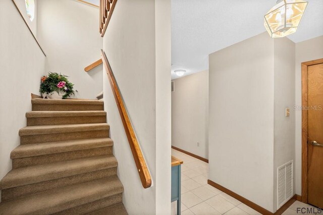 1951 N Daytona Ave, Flagler Beach, FL 32136 - staircase with tile patterned floors, baseboards, and visible vents