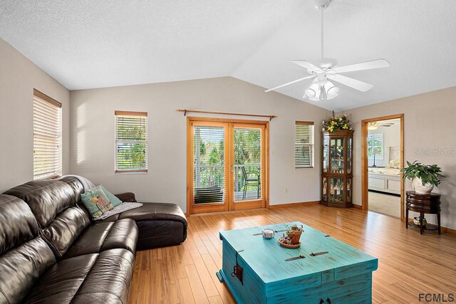 1951 N Daytona Ave, Flagler Beach, FL 32136 - living area with vaulted ceiling, a ceiling fan, light wood finished floors, a textured ceiling, and baseboards
