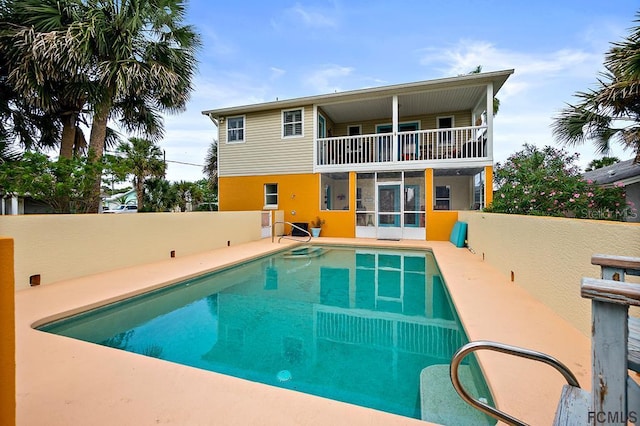 1951 N Daytona Ave, Flagler Beach, FL 32136 - rear view of house with a balcony, fence, and a fenced in pool