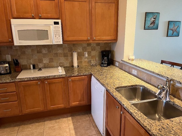 102 Yacht Harbor Dr Unit 375, Palm Coast, FL 32137 - kitchen with brown cabinets, tasteful backsplash, a sink, and white appliances