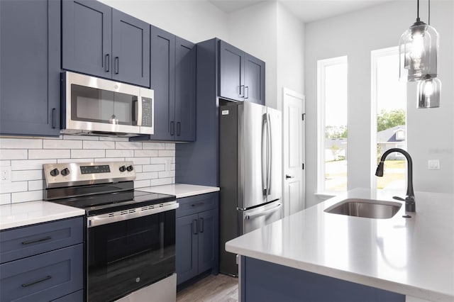 6 Rainbow Ln, Palm Coast, FL 32164 - kitchen featuring appliances with stainless steel finishes, tasteful backsplash, light countertops, blue cabinets, and pendant lighting