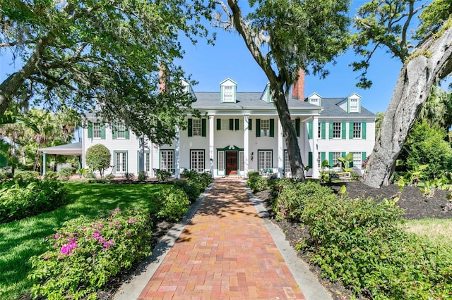 greek revival house with a chimney and a front lawn