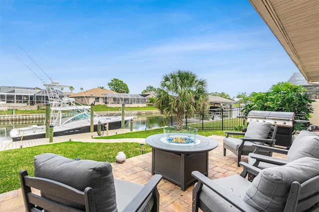 view of patio featuring area for grilling, fence, an outdoor living space with a fire pit, a water view, and a boat dock