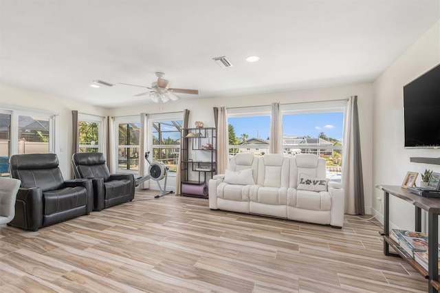 living area featuring light wood-type flooring, a ceiling fan, plenty of natural light, and visible vents