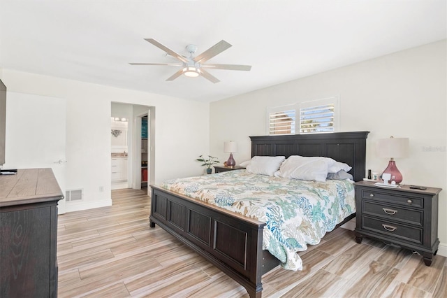 bedroom featuring visible vents, baseboards, connected bathroom, a ceiling fan, and light wood-style floors