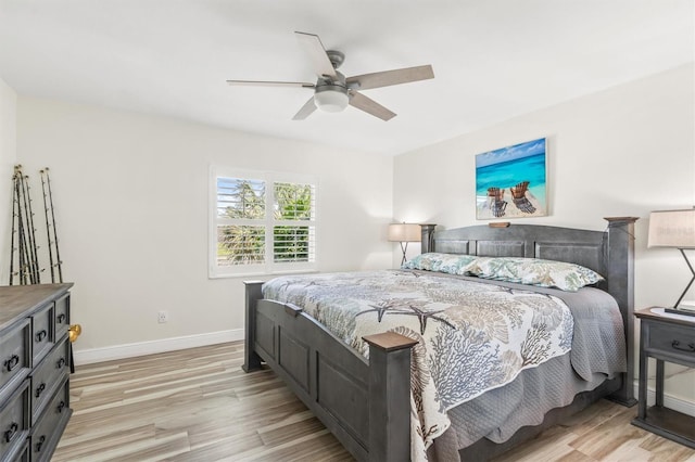 bedroom featuring baseboards, light wood-style flooring, and a ceiling fan