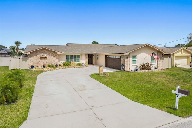 ranch-style home with a gate, concrete driveway, fence, an attached garage, and a front lawn