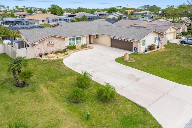 view of front facade featuring fence, a residential view, driveway, and an attached garage