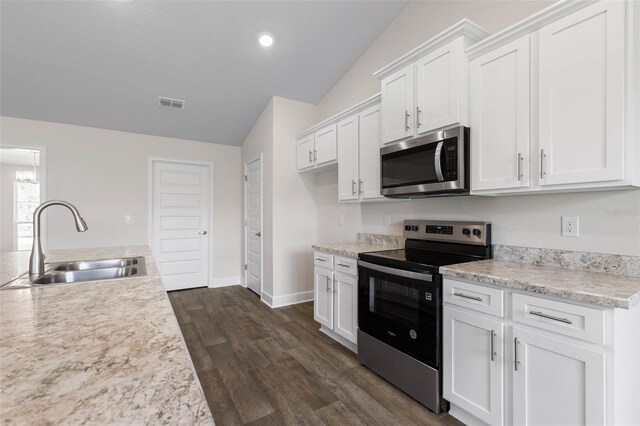 12 Squanto Pl, Palm Coast, FL 32164 - kitchen with stainless steel appliances, a sink, vaulted ceiling, light countertops, and white cabinets