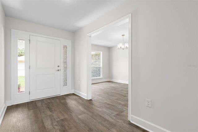 12 Squanto Pl, Palm Coast, FL 32164 - foyer entrance featuring a chandelier, dark wood-style floors, baseboards, and plenty of natural light