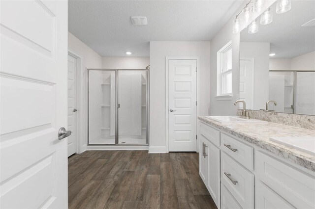12 Squanto Pl, Palm Coast, FL 32164 - bathroom with a shower stall, double vanity, wood finished floors, recessed lighting, and baseboards