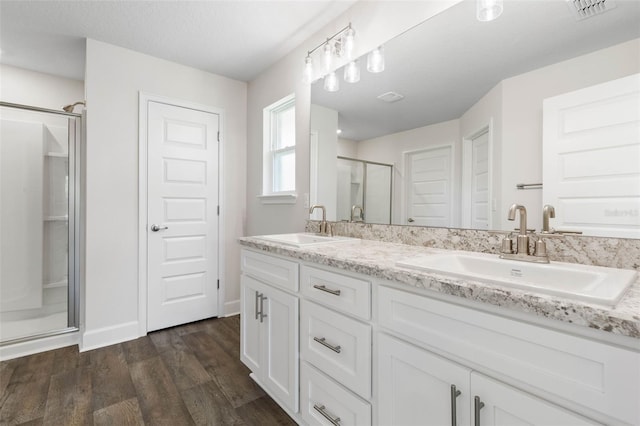 12 Squanto Pl, Palm Coast, FL 32164 - bathroom featuring a stall shower, double vanity, wood finished floors, and baseboards
