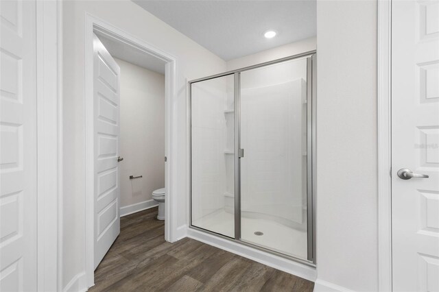 12 Squanto Pl, Palm Coast, FL 32164 - bathroom featuring a stall shower, toilet, wood finished floors, baseboards, and recessed lighting