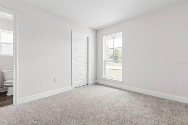 12 Squanto Pl, Palm Coast, FL 32164 - unfurnished bedroom with carpet flooring, baseboards, and ensuite bath