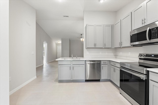 31 Secretary Trl, Palm Coast, FL 32164 - kitchen with light countertops, a sink, appliances with stainless steel finishes, a peninsula, and gray cabinetry