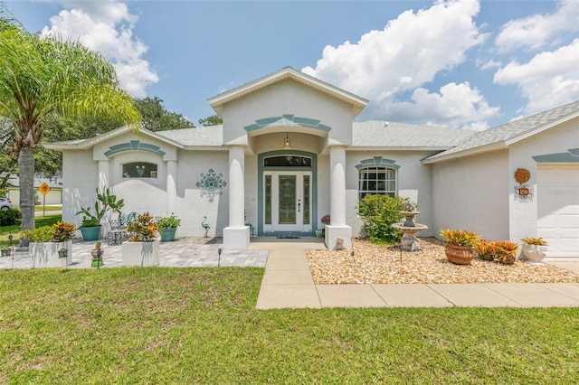 42 Buffalo Bill Dr, Palm Coast, FL 32137 - view of front facade featuring french doors, a garage, stucco siding, and a front yard