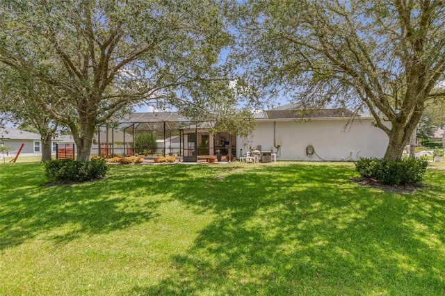 42 Buffalo Bill Dr, Palm Coast, FL 32137 - back of house featuring a yard, glass enclosure, and stucco siding