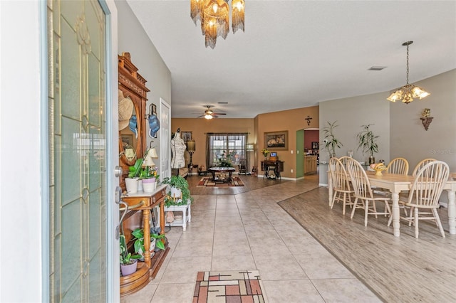 42 Buffalo Bill Dr, Palm Coast, FL 32137 - foyer entrance with light tile patterned floors, visible vents, ceiling fan with notable chandelier, and baseboards