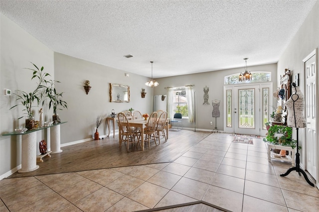42 Buffalo Bill Dr, Palm Coast, FL 32137 - dining room with light tile patterned floors, a textured ceiling, and an inviting chandelier