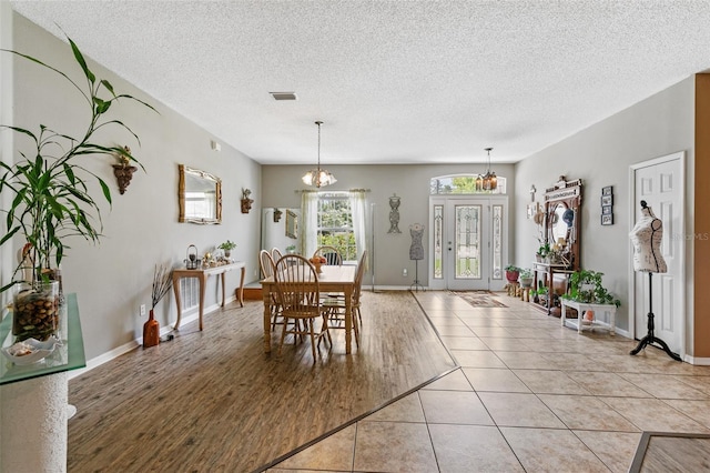 42 Buffalo Bill Dr, Palm Coast, FL 32137 - dining space with a chandelier, a textured ceiling, light tile patterned flooring, and visible vents