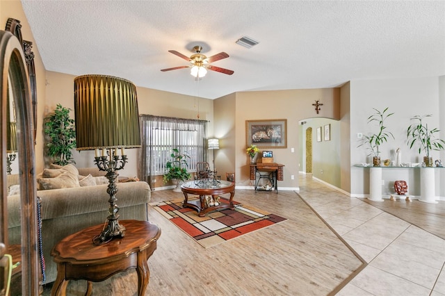 42 Buffalo Bill Dr, Palm Coast, FL 32137 - living room featuring tile patterned flooring, a textured ceiling, a ceiling fan, visible vents, and arched walkways