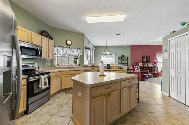 42 Buffalo Bill Dr, Palm Coast, FL 32137 - kitchen with light tile patterned floors, light countertops, stainless steel appliances, a sink, and light brown cabinetry