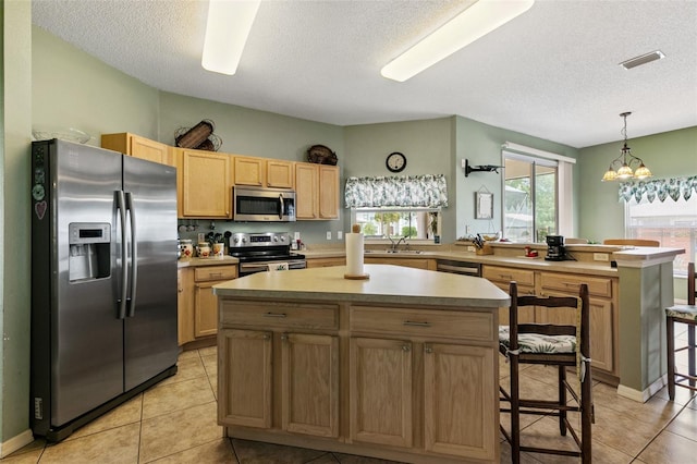 42 Buffalo Bill Dr, Palm Coast, FL 32137 - kitchen featuring an inviting chandelier, a peninsula, light countertops, a center island, and appliances with stainless steel finishes
