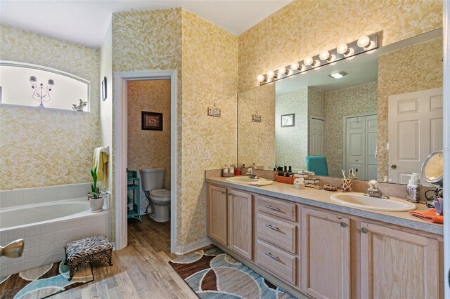 42 Buffalo Bill Dr, Palm Coast, FL 32137 - bathroom with a sink, a bath, wood finished floors, and wallpapered walls