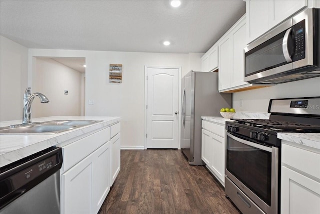 619 Grand Reserve Dr, Bunnell, FL 32110 - kitchen with white cabinetry, appliances with stainless steel finishes, light countertops, a sink, and dark wood-style floors