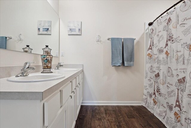 619 Grand Reserve Dr, Bunnell, FL 32110 - full bath with wood finished floors, double vanity, a sink, and baseboards