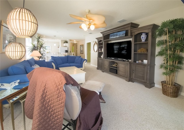 living room with light carpet, baseboards, a ceiling fan, and visible vents