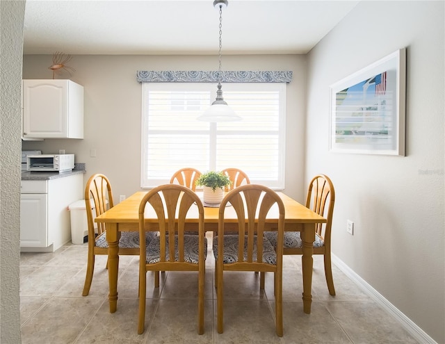 dining space with baseboards and light tile patterned flooring