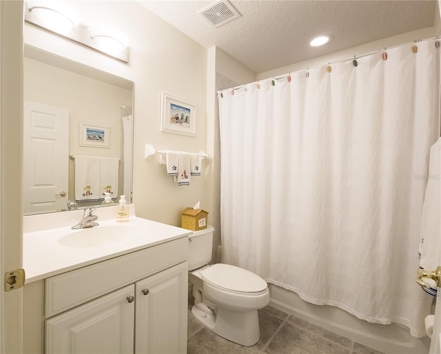 bathroom featuring a textured ceiling, vanity, visible vents, toilet, and tile patterned floors