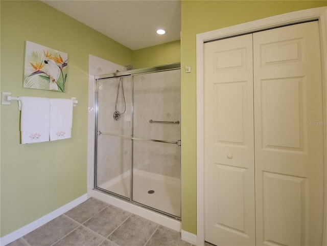 full bath featuring baseboards, a shower stall, and tile patterned flooring