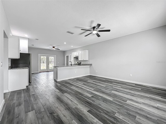 10625 Amos Ave, Hastings, FL 32145 - unfurnished living room featuring dark wood finished floors, visible vents, baseboards, and ceiling fan
