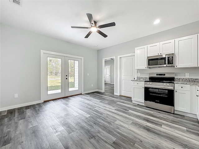 10625 Amos Ave, Hastings, FL 32145 - kitchen with light wood-type flooring, ceiling fan, baseboards, and stainless steel appliances