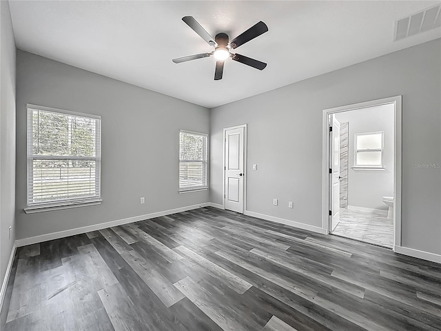 10625 Amos Ave, Hastings, FL 32145 - unfurnished bedroom with dark wood-type flooring, visible vents, baseboards, and connected bathroom