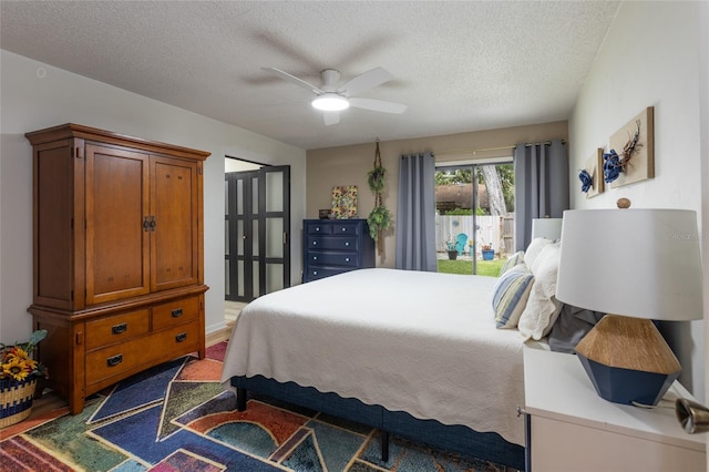 bedroom with ceiling fan, access to outside, and a textured ceiling