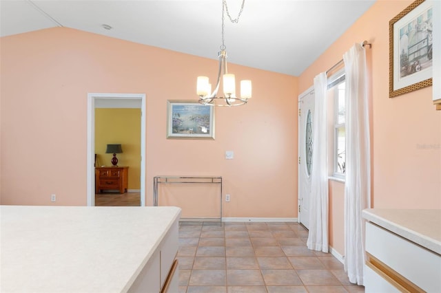 unfurnished dining area with light tile patterned floors, baseboards, a notable chandelier, and vaulted ceiling