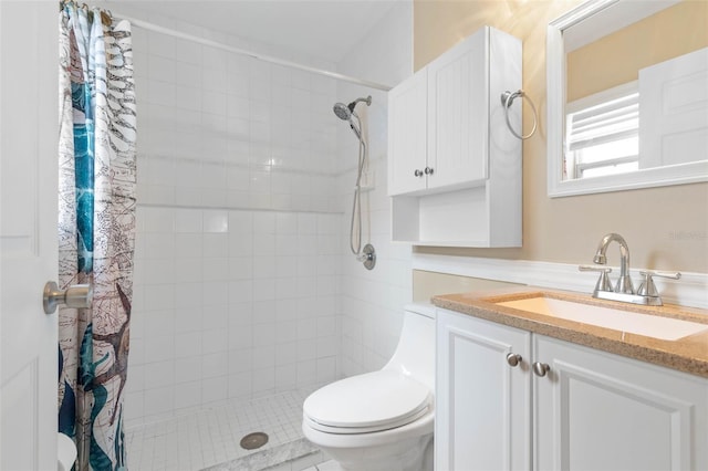 full bathroom featuring toilet, tiled shower, and vanity