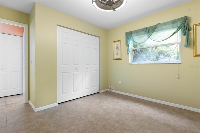 unfurnished bedroom featuring a closet and baseboards