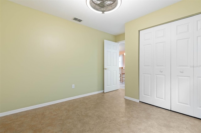 unfurnished bedroom with a closet, baseboards, and visible vents