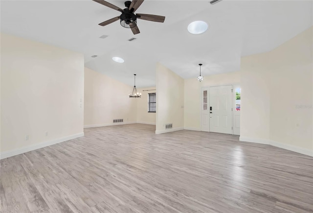 75 Fortune Ln, Palm Coast, FL 32137 - unfurnished living room with a chandelier, lofted ceiling, light wood finished floors, and a ceiling fan