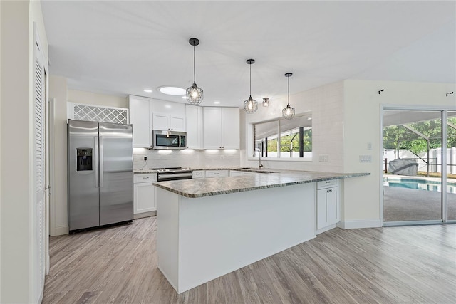 75 Fortune Ln, Palm Coast, FL 32137 - kitchen with stainless steel appliances, a peninsula, light wood-type flooring, and healthy amount of natural light