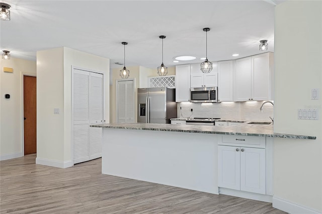 75 Fortune Ln, Palm Coast, FL 32137 - kitchen with stainless steel appliances, a peninsula, backsplash, light wood finished floors, and recessed lighting