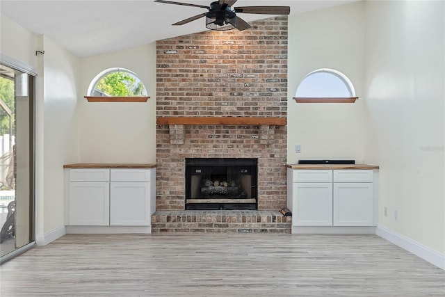75 Fortune Ln, Palm Coast, FL 32137 - unfurnished living room featuring light wood finished floors, a ceiling fan, lofted ceiling, and a brick fireplace