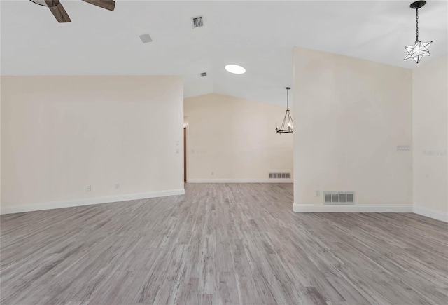 75 Fortune Ln, Palm Coast, FL 32137 - unfurnished living room with lofted ceiling, light wood-style flooring, a ceiling fan, and a chandelier