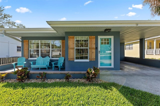 doorway to property featuring an attached carport and a porch